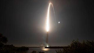 streak of a rocket lifting off into space in the black night