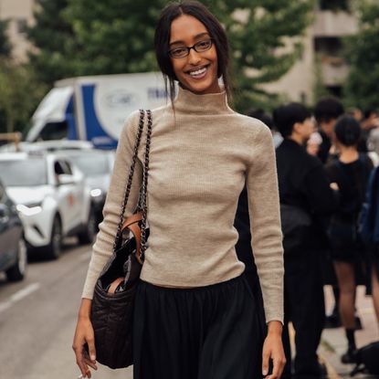 woman wearing a turtleneck and a skirt