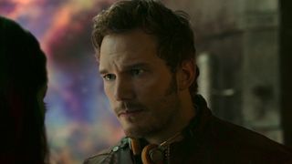 Star-Lord with his headphones around his neck talking to Gamora in Guardians 1. 