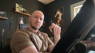 image of a man with a stylus in front of a drawing tablet in his studio