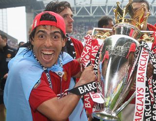 Carlos Tevez celebrates with the Premier League trophy after winning the 2007/08 title with Manchester United