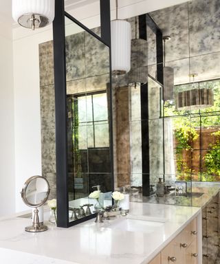 A bathroom with antiqued glass behind the console