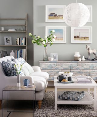 Neutral living room with white photo frames on the wall