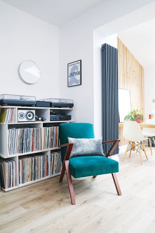 Corner of snug with vinyl storage and a teal armchair