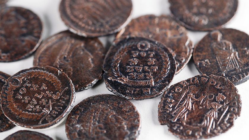 A pile of Roman copper coins on a white surface