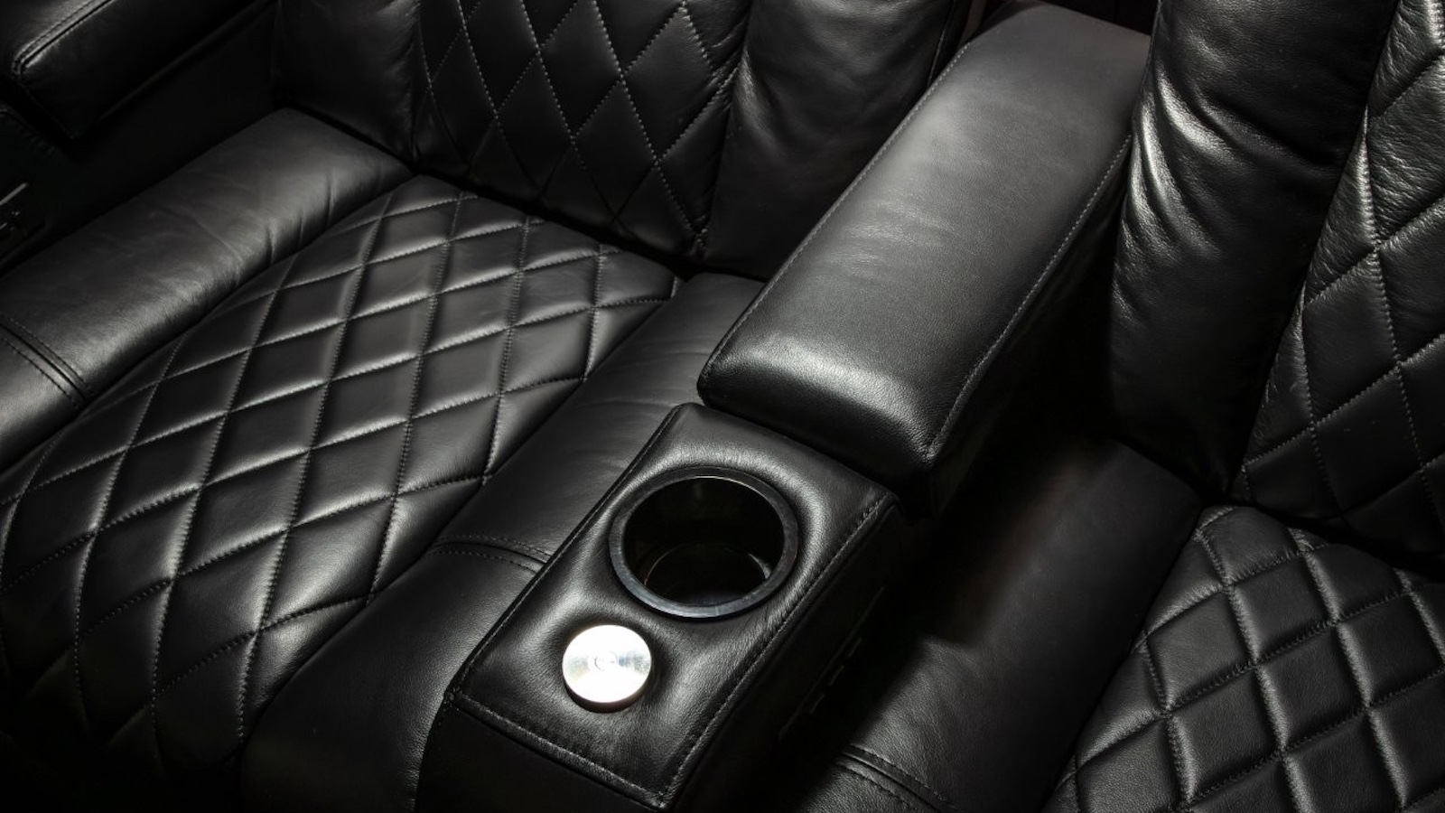 A photo of a custom-installed home cinema room featuring a 4K projector, theatre seating and clever acoustic treatment