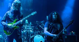 Mikael Åkerfeldt and Fredrik Åkesson are bathed in deep blue stagelights as they play their PRS electric guitars onstage in Mexico with Opeth.