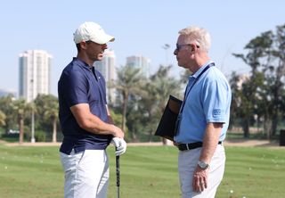 Rory McIlroy and Keith Pelley chat on the range at the Dubai Desert Classic