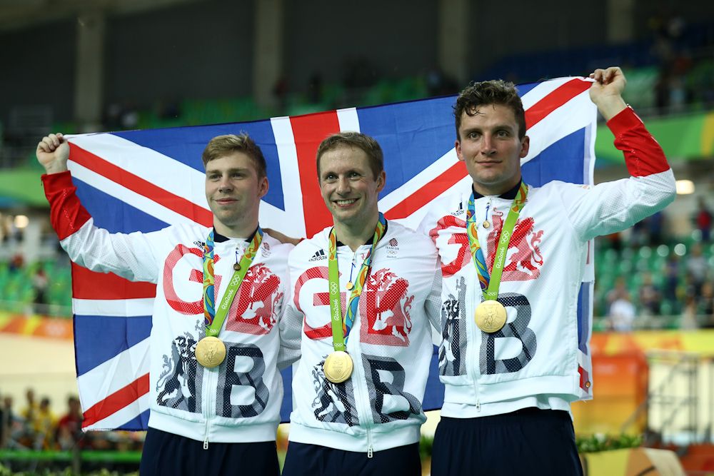 Philip Hindes, Jason Kenny and Callum Skinner of Great Britain celebrate after winning gold and getting an Olympic record in the Men's Team Sprint