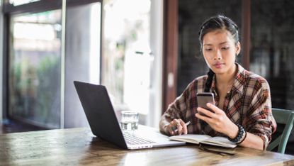 a young beautiful woman works at her laptop in a modern office space