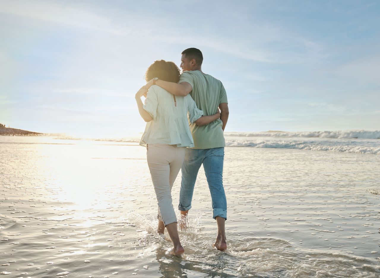 back of couple at the beach walking