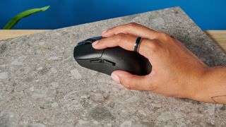 A black Lemokey G1 wireless gaming mouse sitting on a marble slab