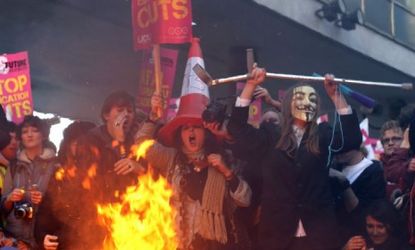Student protesters burn placards and chant "Tory scum" before storming David Cameron's Conservative Party headquarters in London.