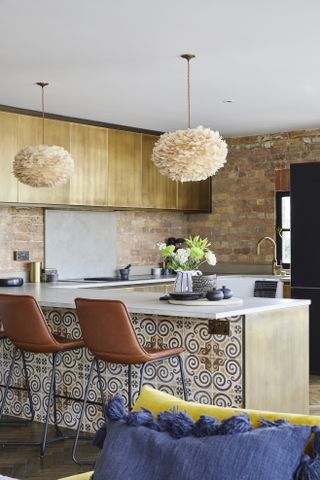 Kitchen with peninsular cabinets with patterned tile, bar stools and wood cabinets