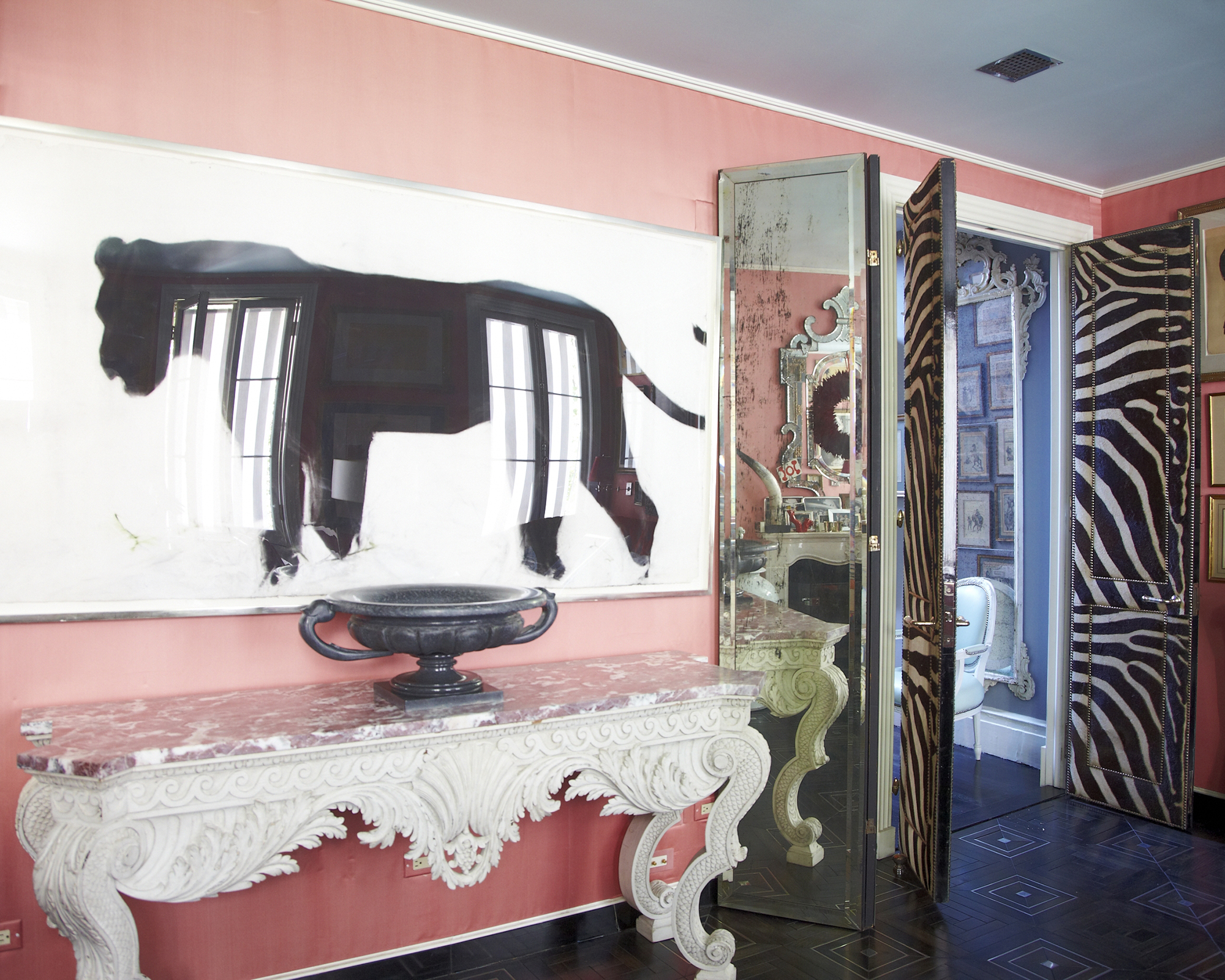 pink living room with white console underneath a big piece of graphic black and white art