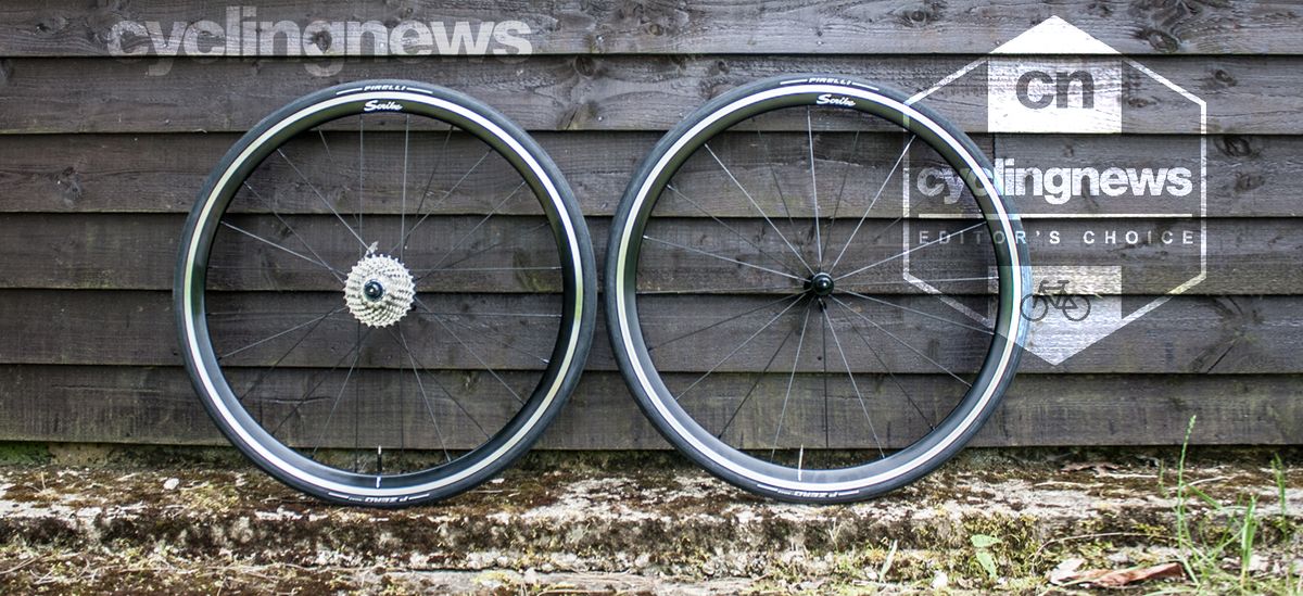 Scribe Pace rim brake wheels resting against a wooden backdrop