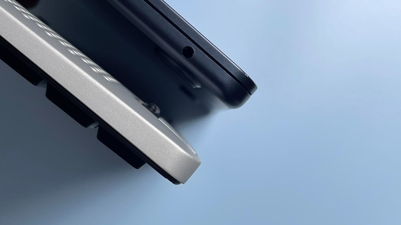 The Lofree Edge keyboard and MacBook Air laptop against a blue background.