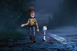 Woody (Tom Hanks) and Forky (Tony Hale) walk on the side of a road in Toy Story 4
