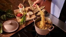 Our Place tiny collection on stove top with noodles, shallot, an egg, and ginger