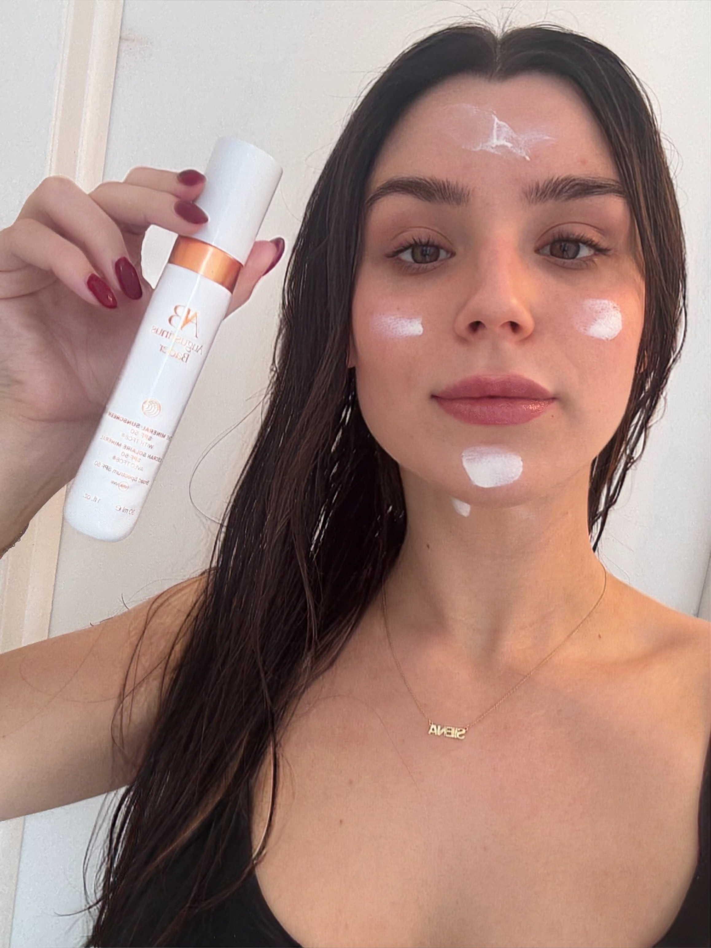 a girl in a black tank top and brown hair before applying spf.