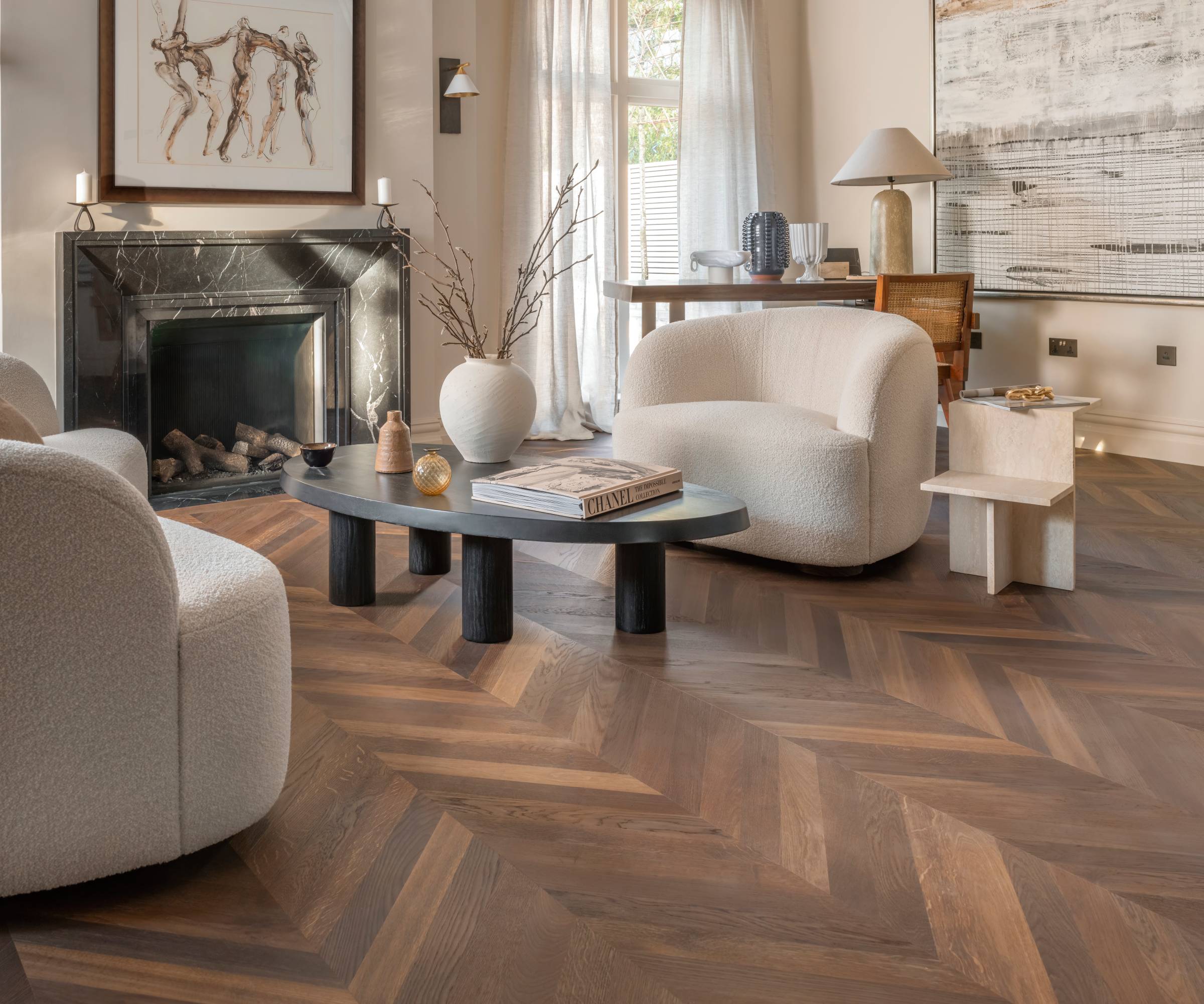 Ted Todd Bloomfield Chevron flooring shown in a contemporary styled lounge with marble fireplace, a desk and comfy lounge chairs in white