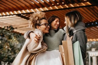 Three female friends enjoying a shopping trip day out together.