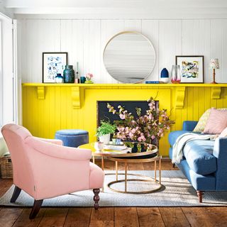 Country style living room with pink chair, fireplace and panelled walls painted yellow and white