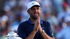 Scottie Scheffler smiles while placing his palms together after winning the 2025 PGA Championship