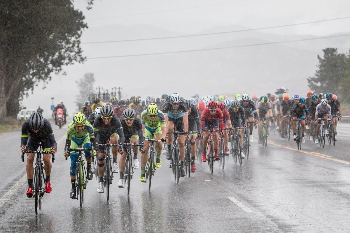 The peloton rides during one of today&rsquo;s downpours.