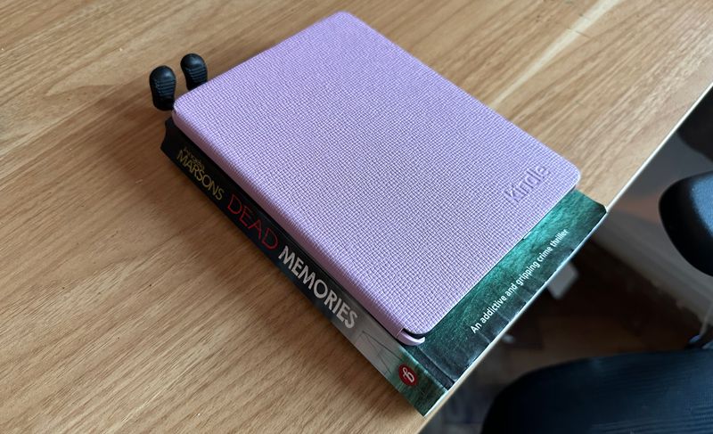 Kindle Paperwhite on top of a paperback book