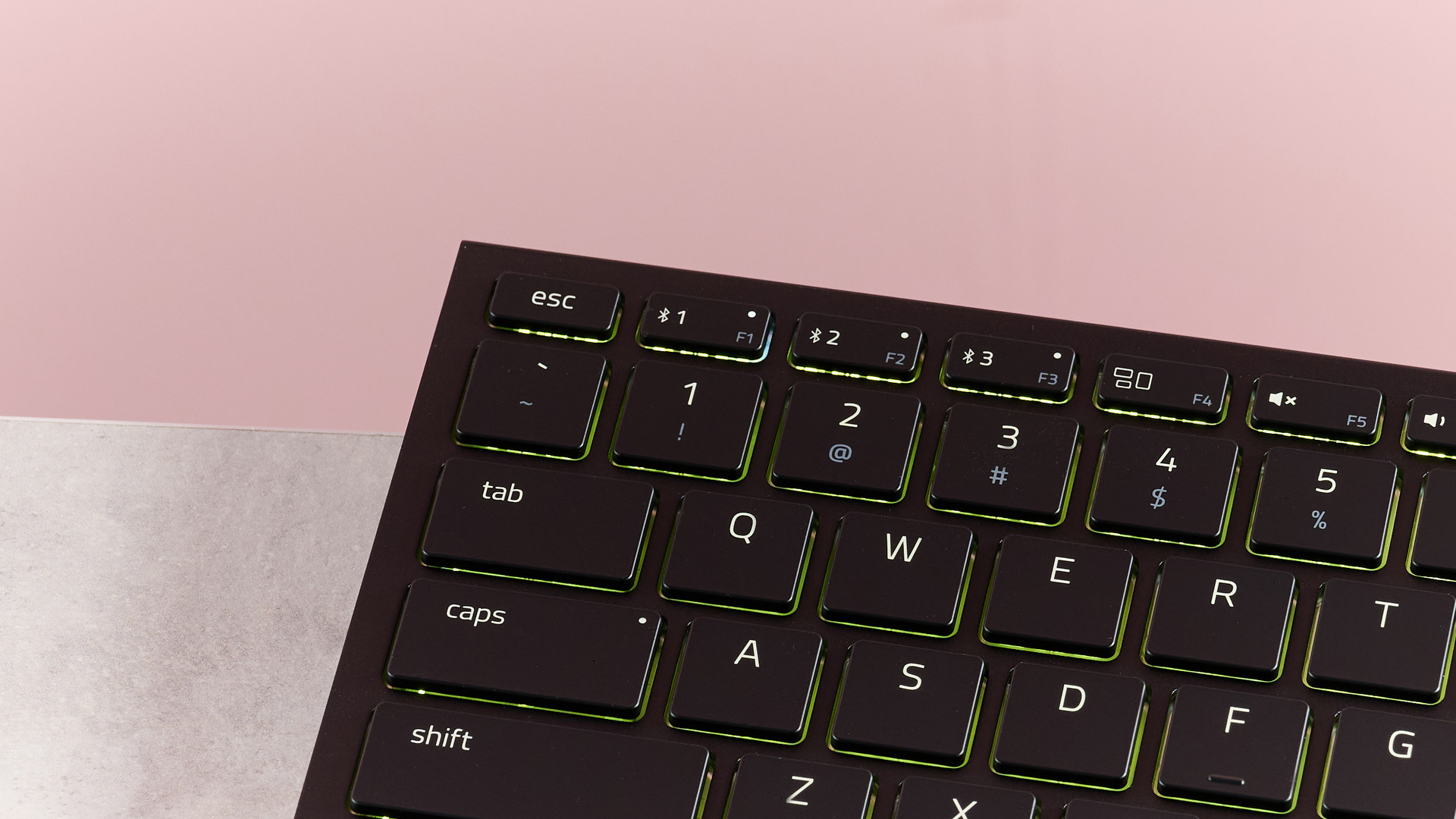 Close-up of left corner of Razer Joro on desk with pink background