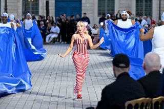 Sabrina Carpenter walks the runway during Vogue World: Paris at Place Vendome on June 23, 2024 in Paris, France in a red and white striped dress.