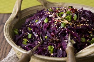 Red cabbage in a dish with serving spoons