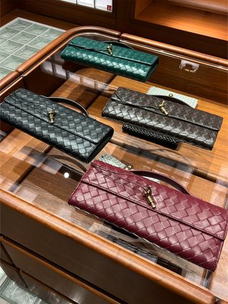 A photo of four different colors of Bottega Veneta's Andiamo clutch.