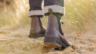 Person wearing Finisterre x Blundstone vegan boots on the beach