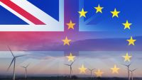 A UK flag and European Union flag with wind turbines in the background