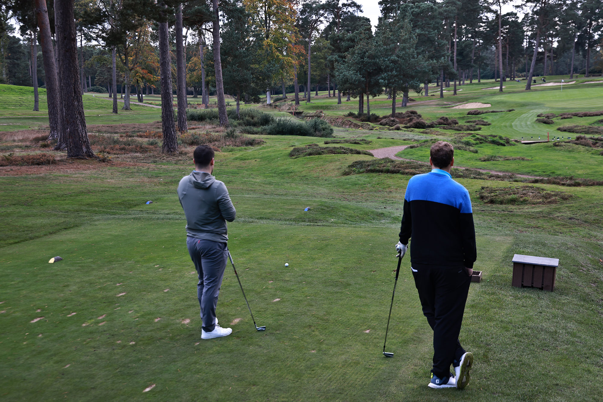 Nick Bonfield and Sam De'Ath playing a par-3, standing on the tee box separately and not talking