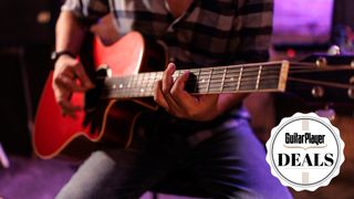 Man plays a red acoustic guitar