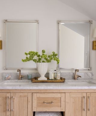 marble topped bathroom sink with wooden cupboards below
