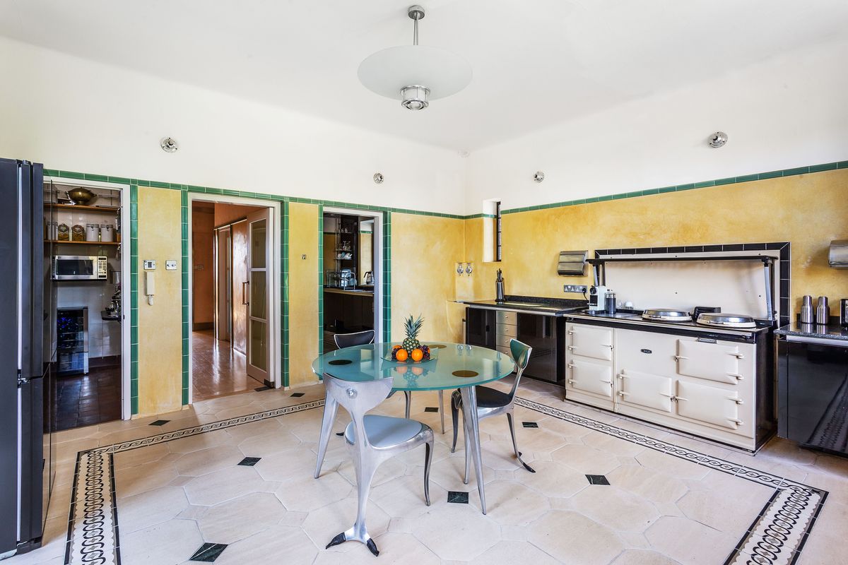 A dining room with a connecting utility room and small stove