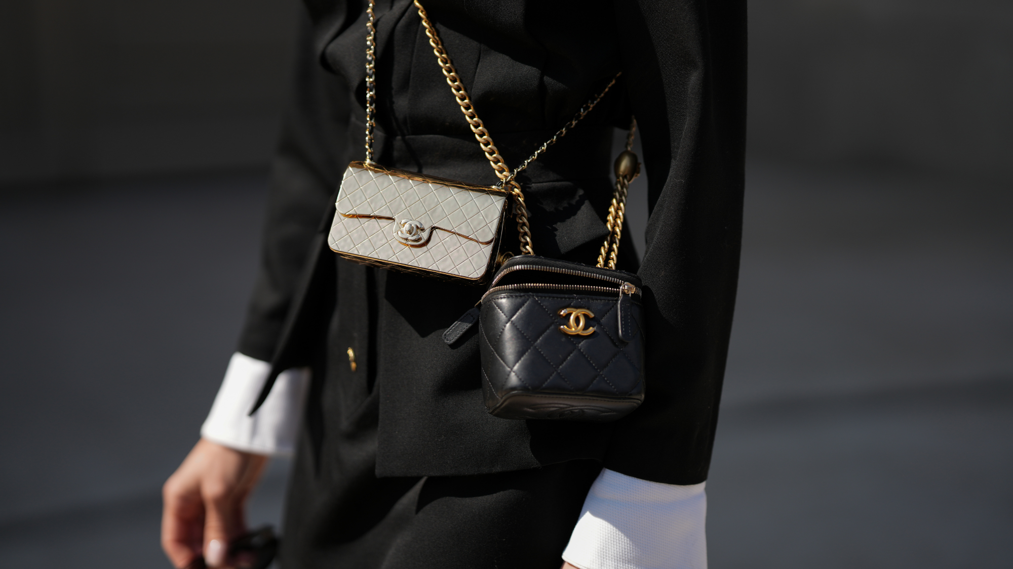 Woman wears black jacket, two Chanel crossbody bags