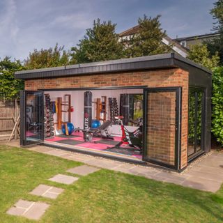 Home gym inside Crown Pavilions garden room with brick exterior