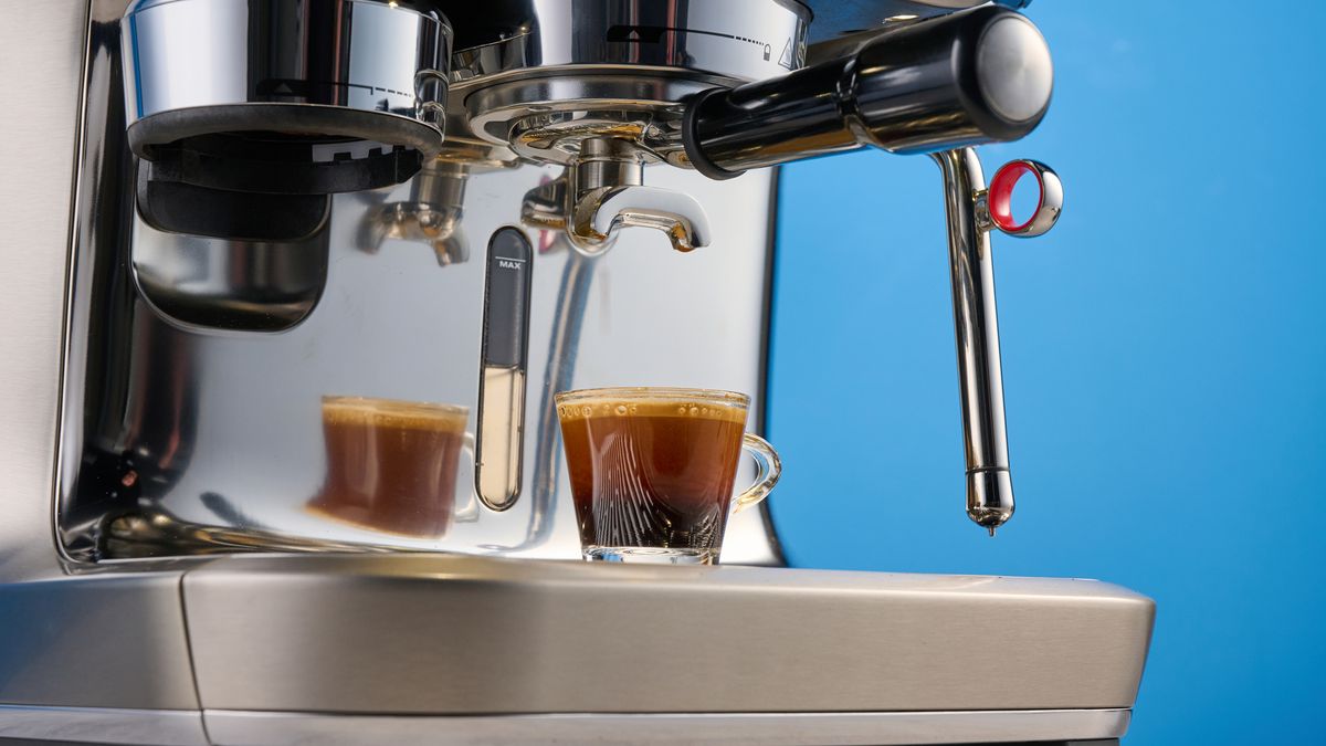 the breville oracle dual boiler / sage oracle dual boiler in stainless steel, showing its touchscreen, steam wand, built in grinder, and espresso shots