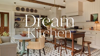 A war, layered kitchen with cream cabinets a wooden freestanding island, and a large plate rack at the top of a built-in hutch-style unit