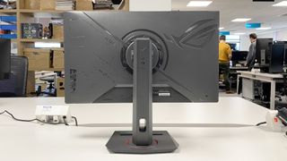 The Asus ROG Strix XG27ACS gaming monitor on a white desk.