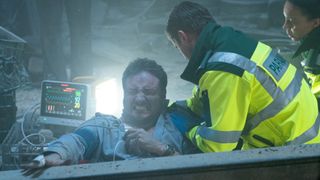 Martin in pain as paramedics work on him in the EastEnders live episode 