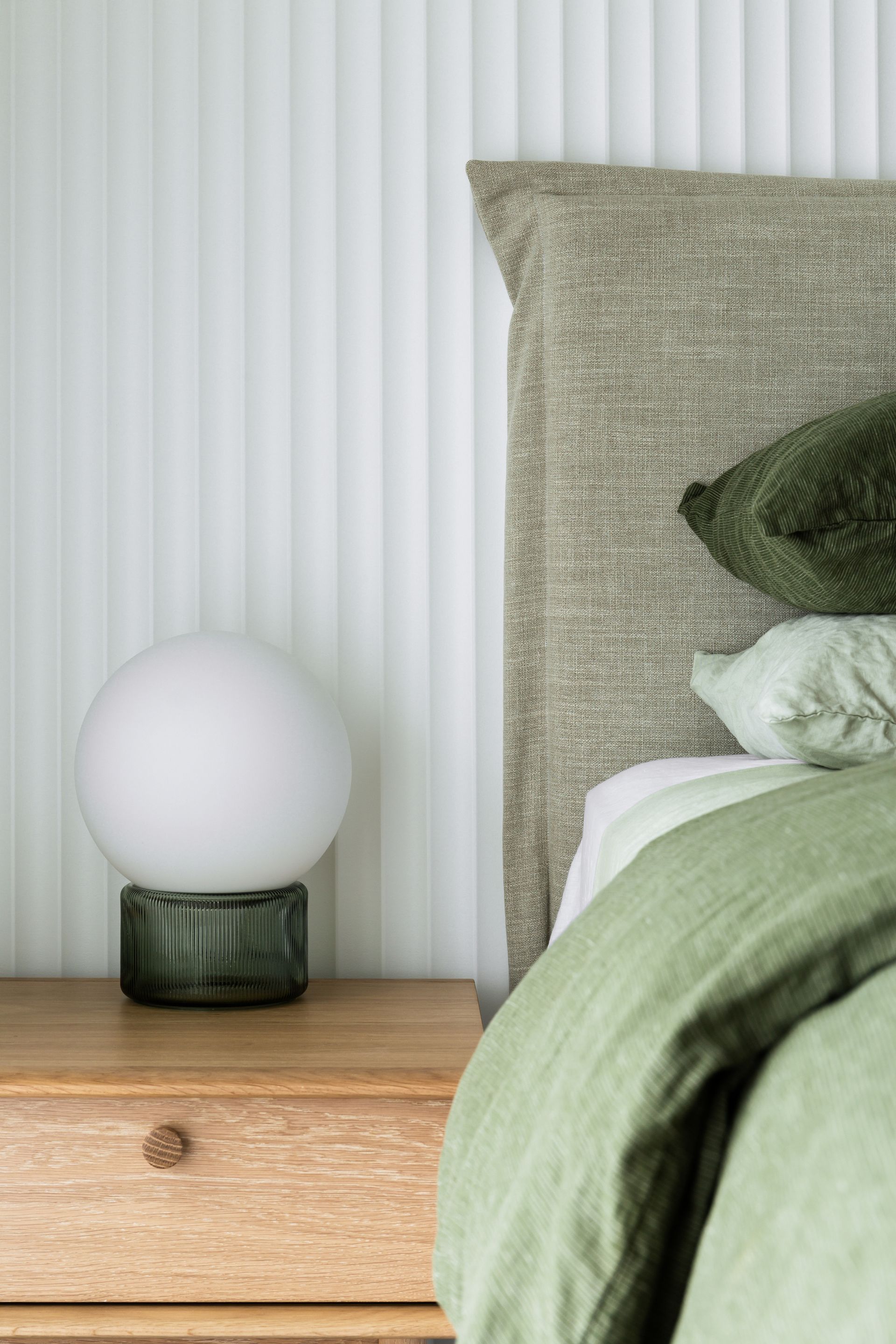 A bedroom with a bedside table lamp