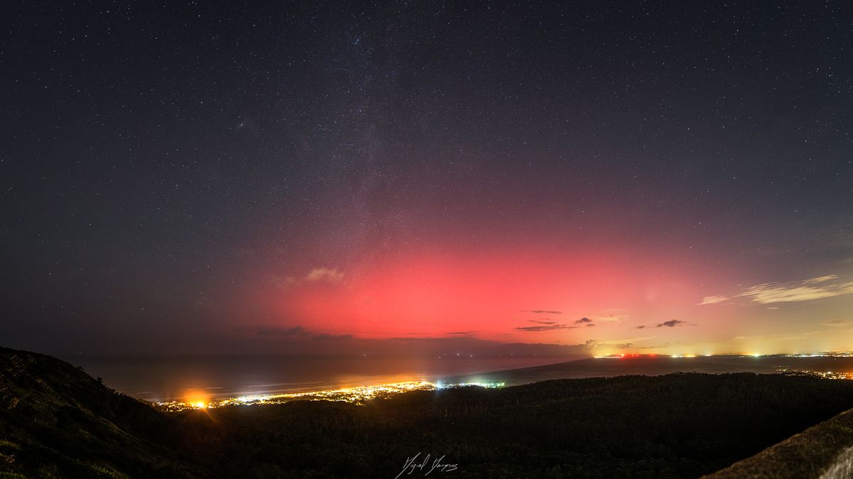 vibrant red light of aurora glows in the sky.