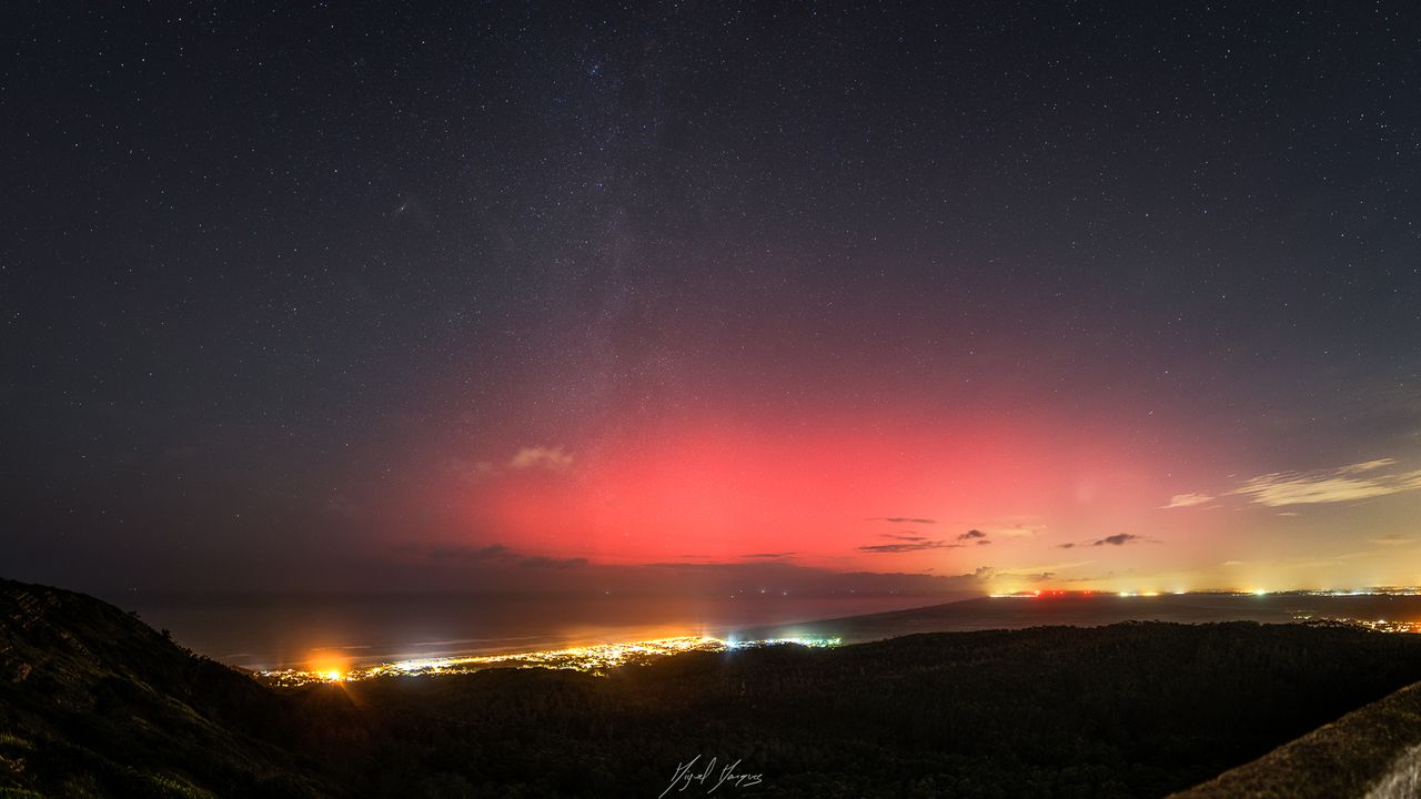 vibrant red light of aurora glows in the sky.