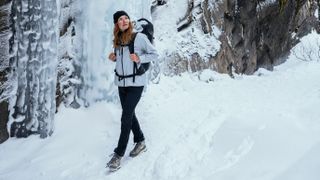 Woman hiking on snowy mountain wearing Jack Wolfskin Tapeless 2.0 jacket